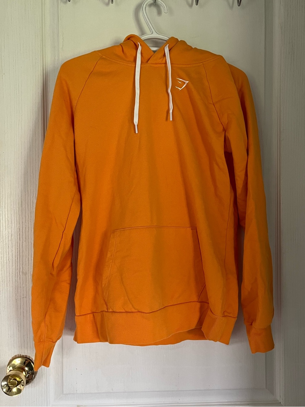 Gymshark Women’s Bright Orange Pullover Hoodie with minor lint on pocket